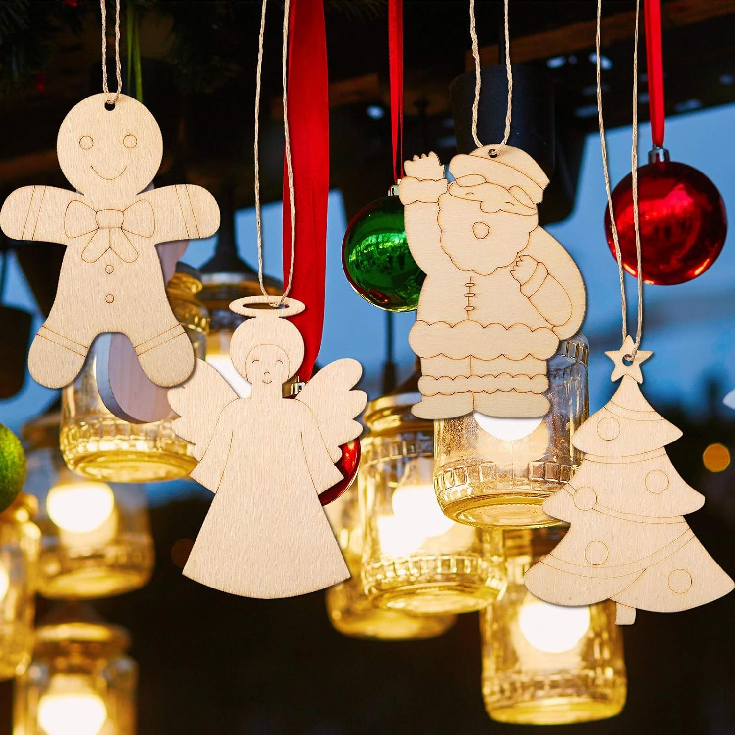 Wooden Christmas ornaments including a gingerbread man, angel, and tree hanging against a blurred background with lights.