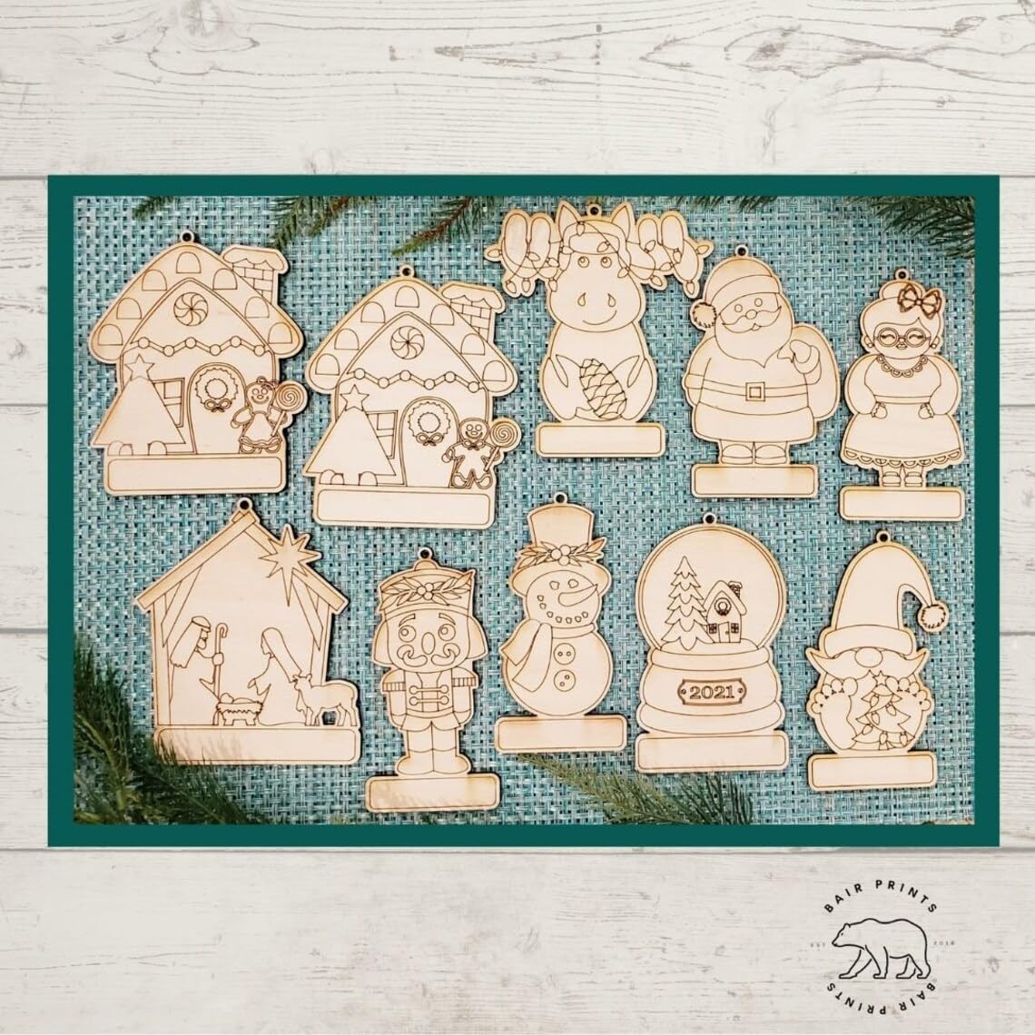 Set of wooden Christmas ornaments on a textured blue mat with a white wooden surface background.