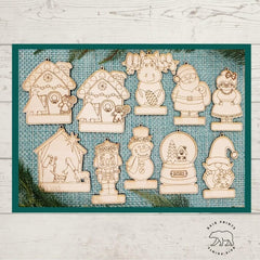 Set of wooden Christmas ornaments on a textured blue mat with a white wooden surface background.