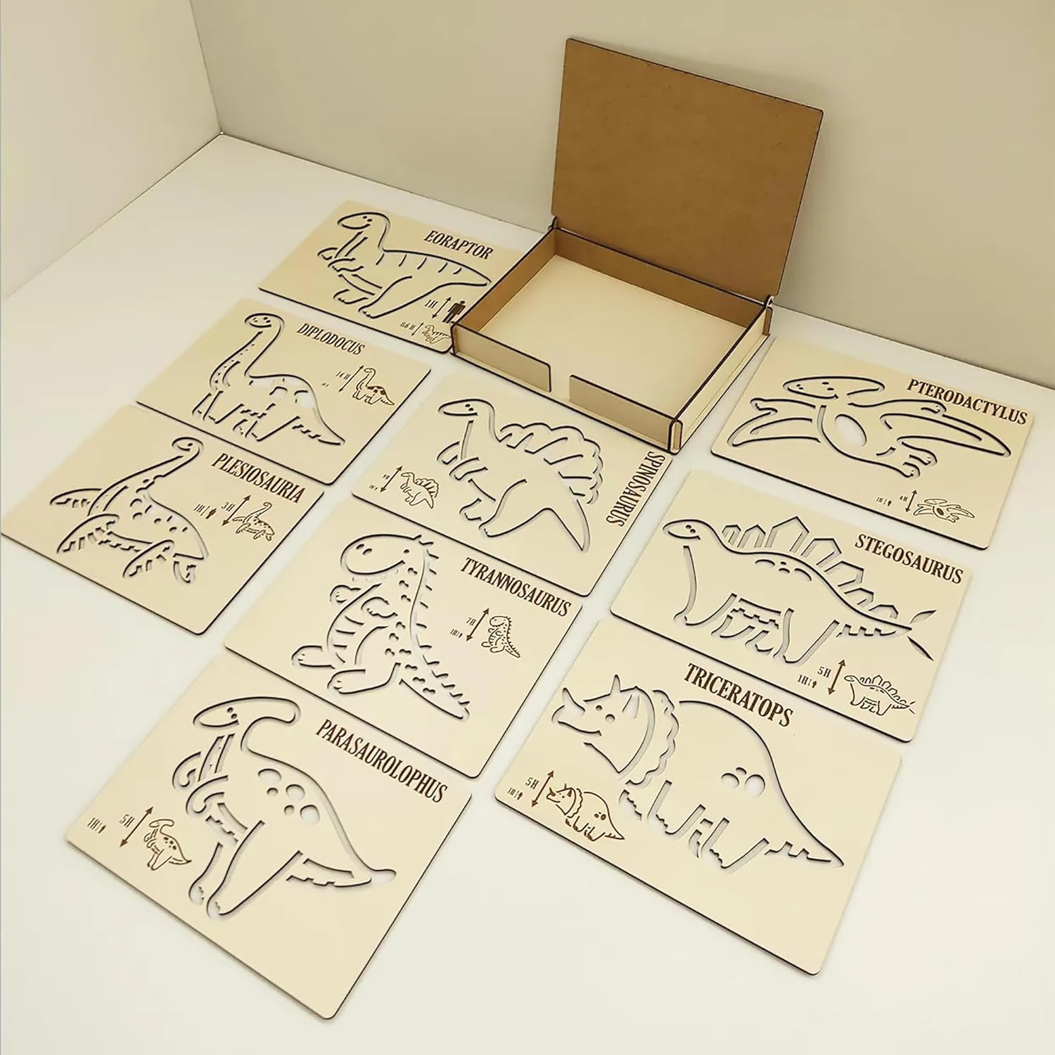 Set of dinosaur-themed wooden cutouts with a cardboard box on a beige background