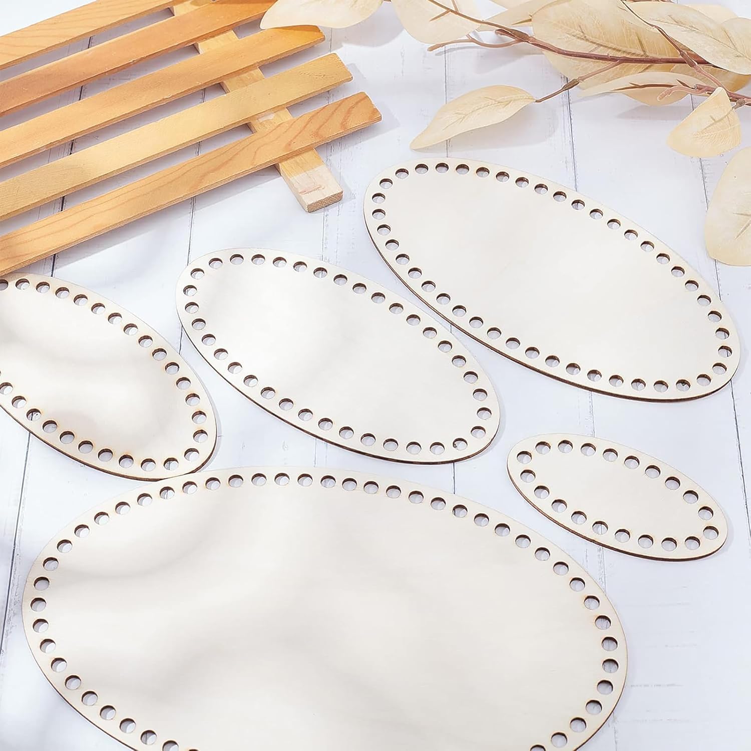 Set of wooden placemats with decorative holes on a light surface.
