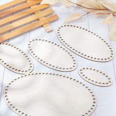 Set of wooden placemats with decorative holes on a light surface.