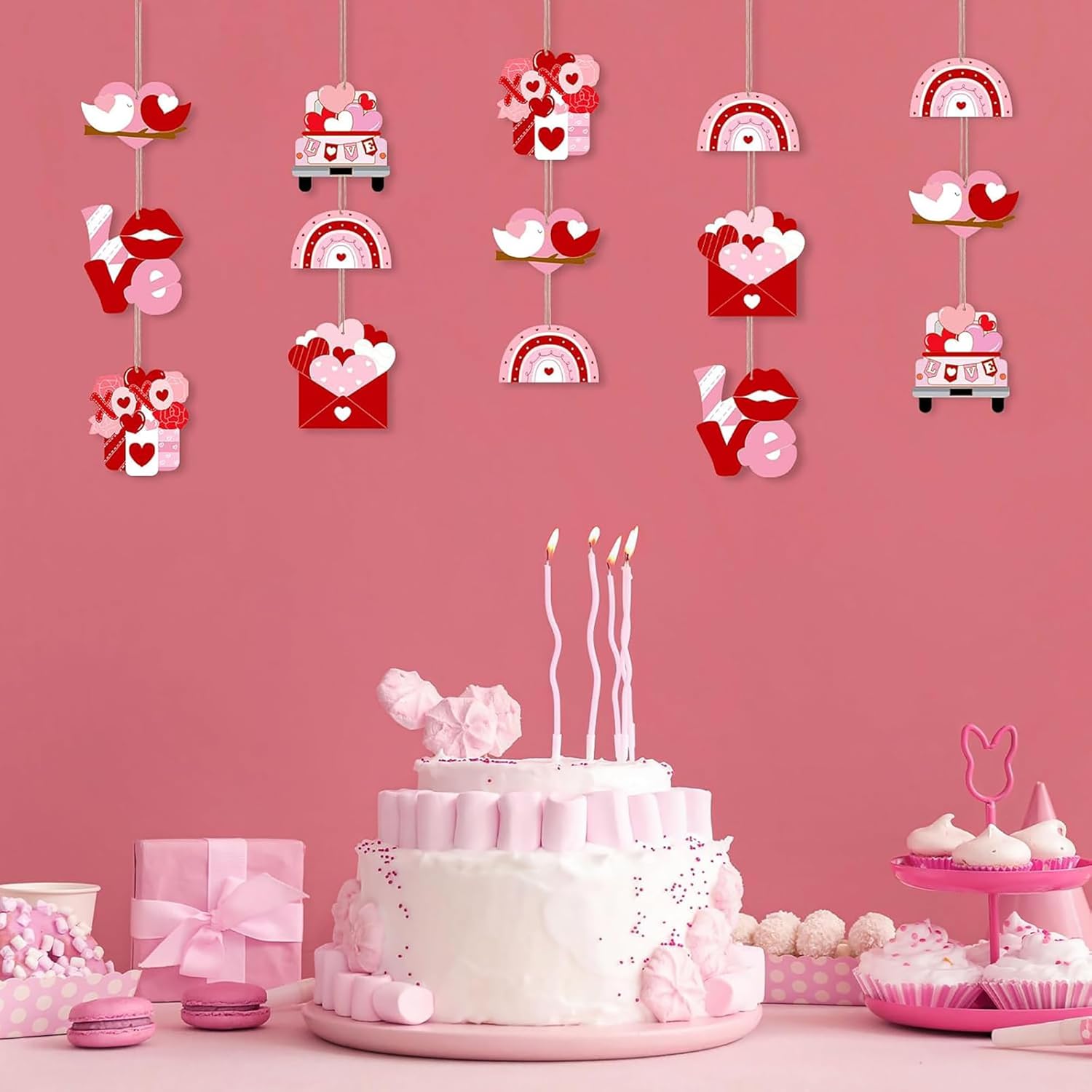 Valentine's Day-themed cake with candles and decorations on a pink background