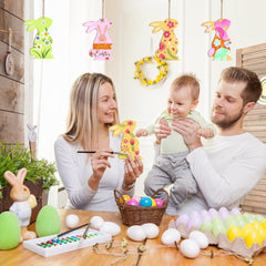 Family with a baby engaging in Easter egg decorating activities.