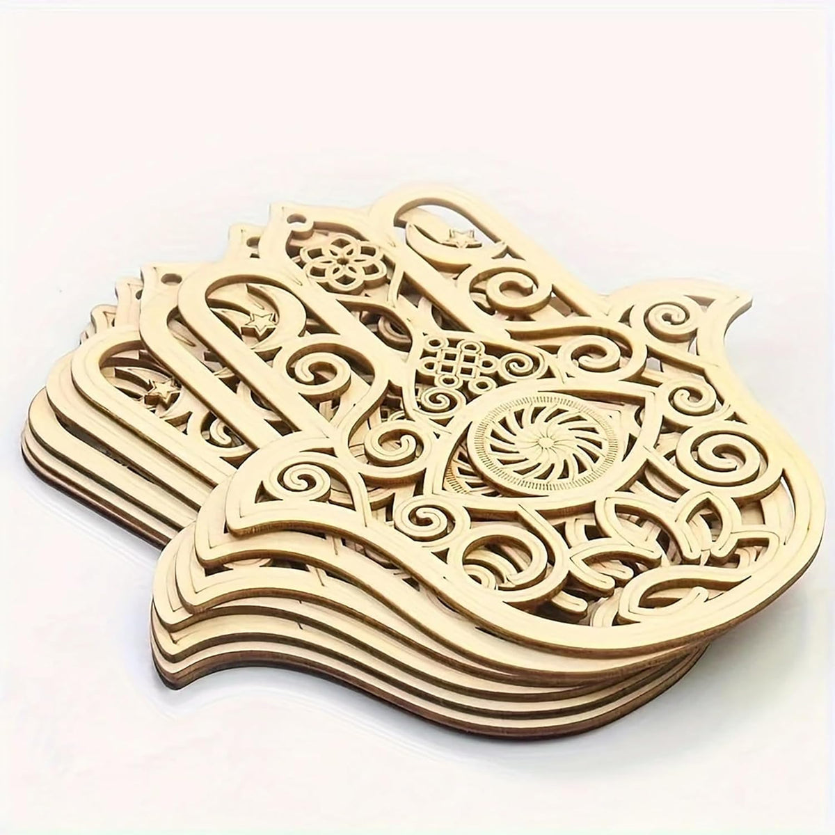 Stack of wooden Hamsa hand decor items with intricate carvings on a white background