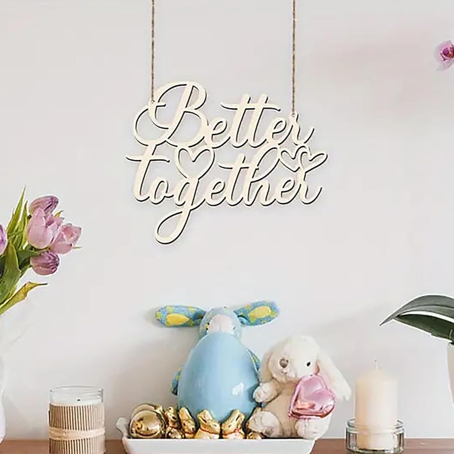 Decorative sign with 'Better Together' on a table with flowers and toys.