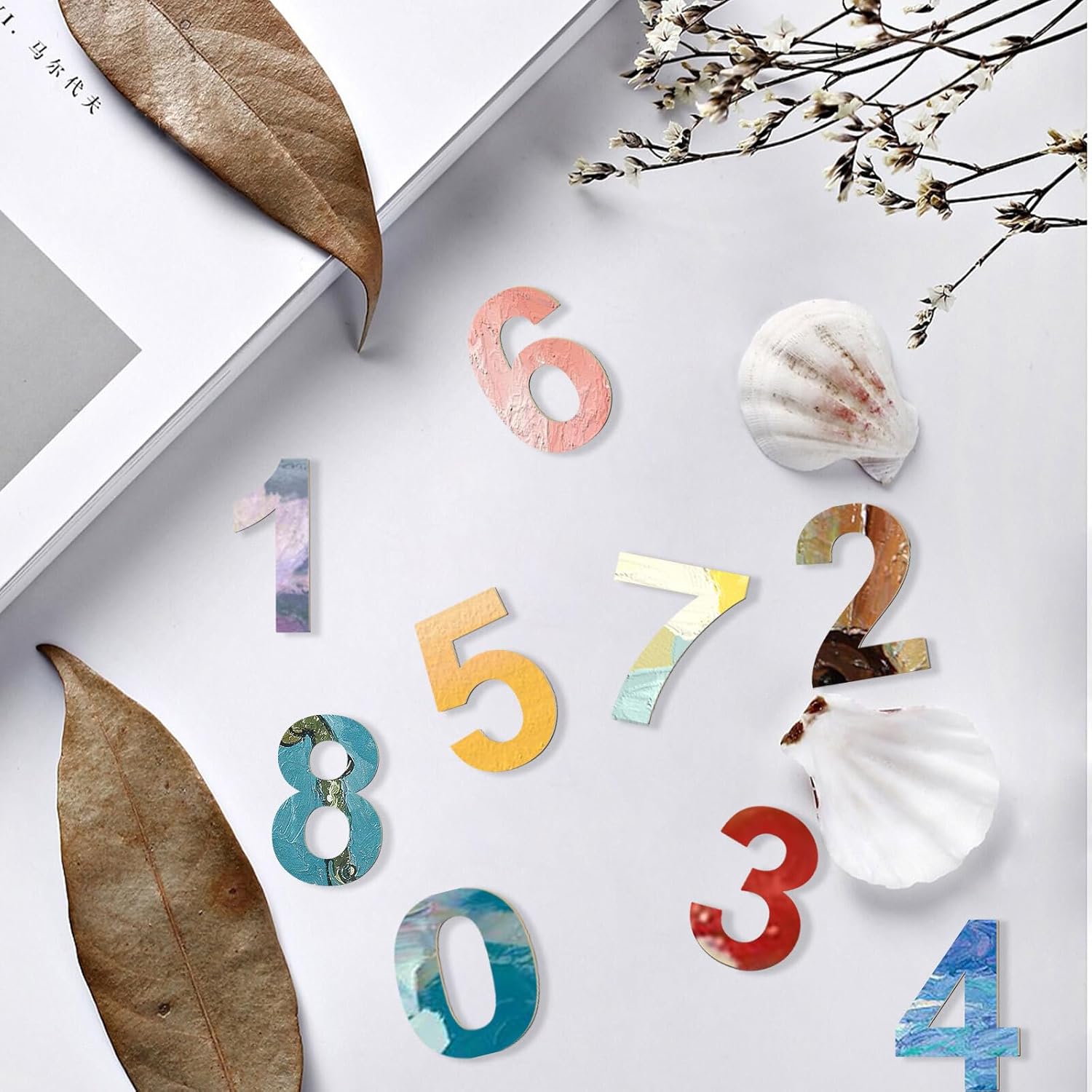 Colorful number stickers on a white surface with leaves and flowers.