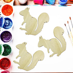 Wooden squirrel shapes with paint and brushes on a table