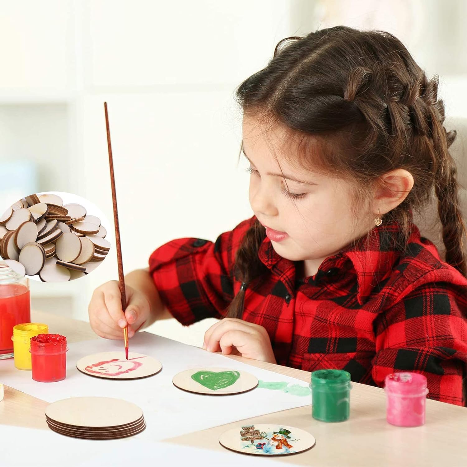 Child painting wooden coasters with colorful paint
