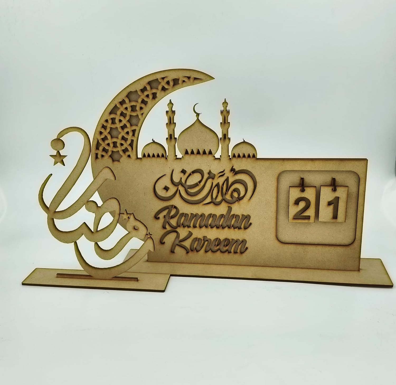 Wooden Ramadan Kareem decorative item with crescent moon, mosque silhouette, and calendar on a white background