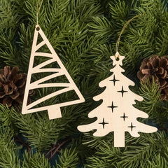 Two wooden Christmas tree ornaments on a green pine branch with pine cones.