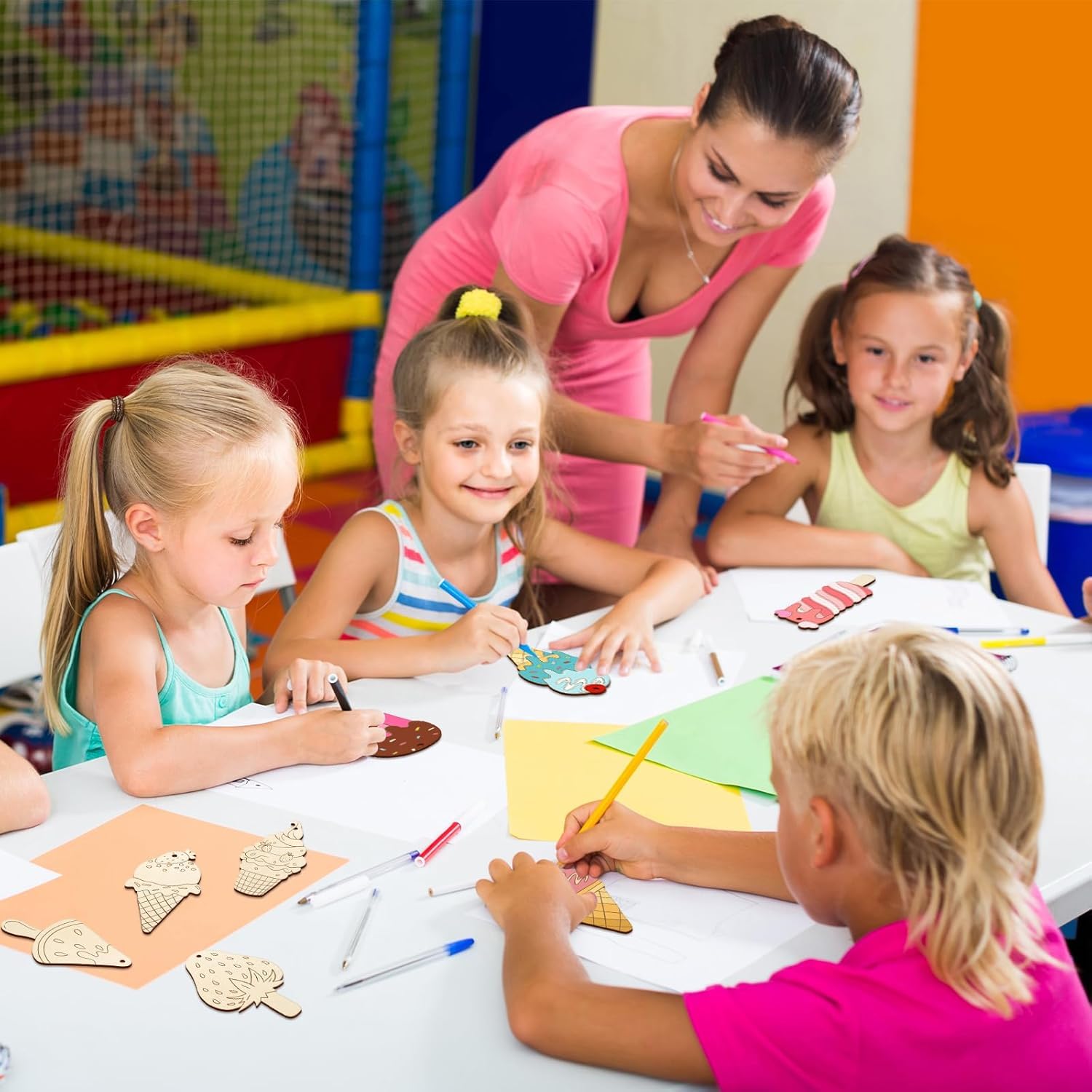 Children engaged in a craft activity with a teacher in a classroom setting.