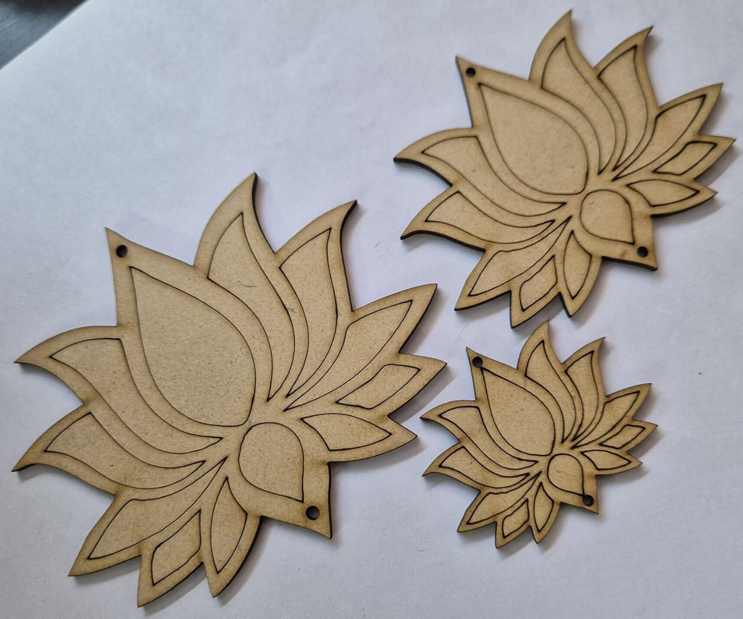 Three wooden lotus flower shapes on a white background