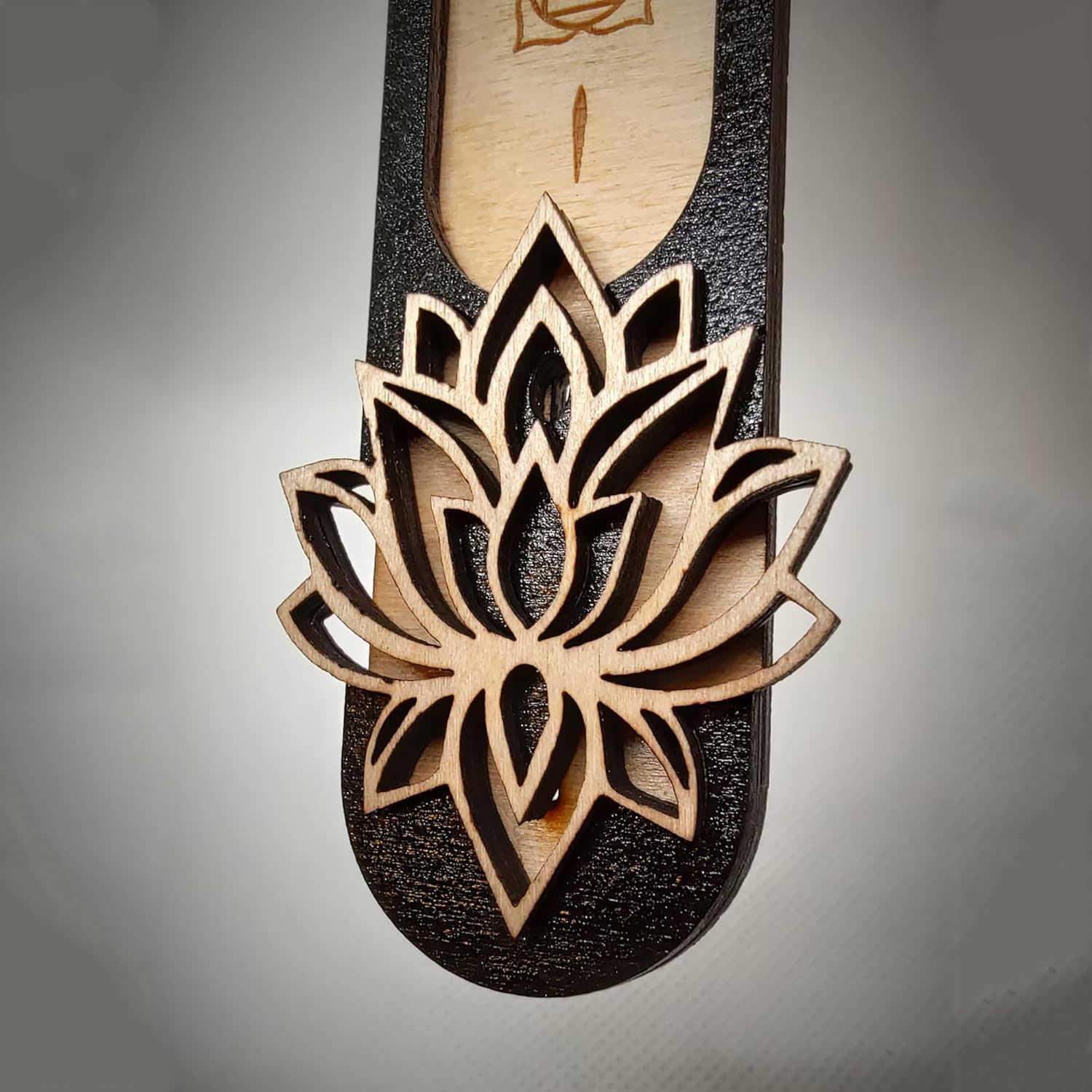 Wooden sandal with a detailed lotus flower design on a gray background