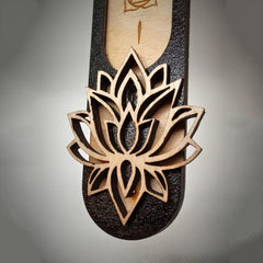 Wooden sandal with a detailed lotus flower design on a gray background