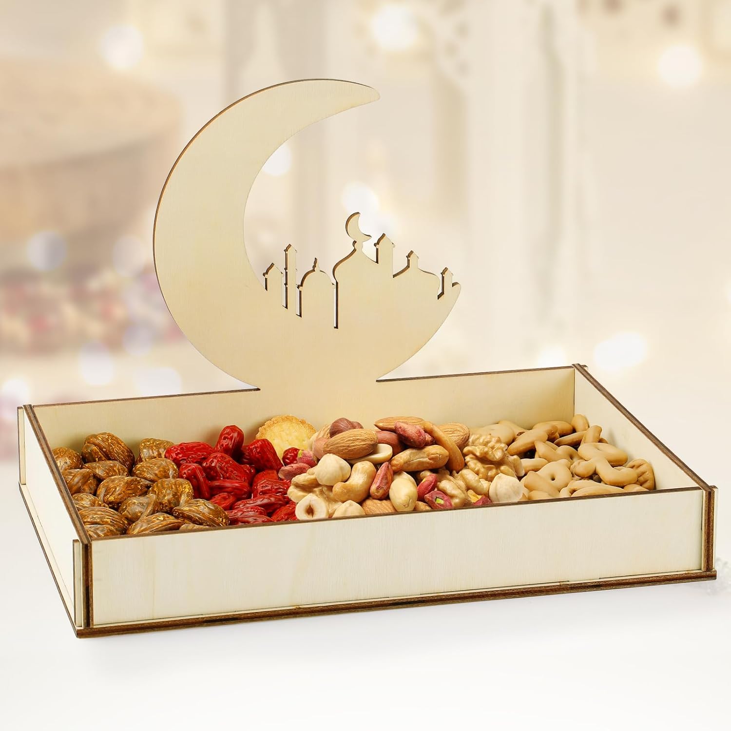 Decorative box with a moon design containing assorted dried fruits and nuts on a blurred background.