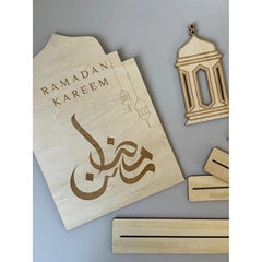 Wooden decorations with 'Ramadan Kareem' and lantern designs on a gray background