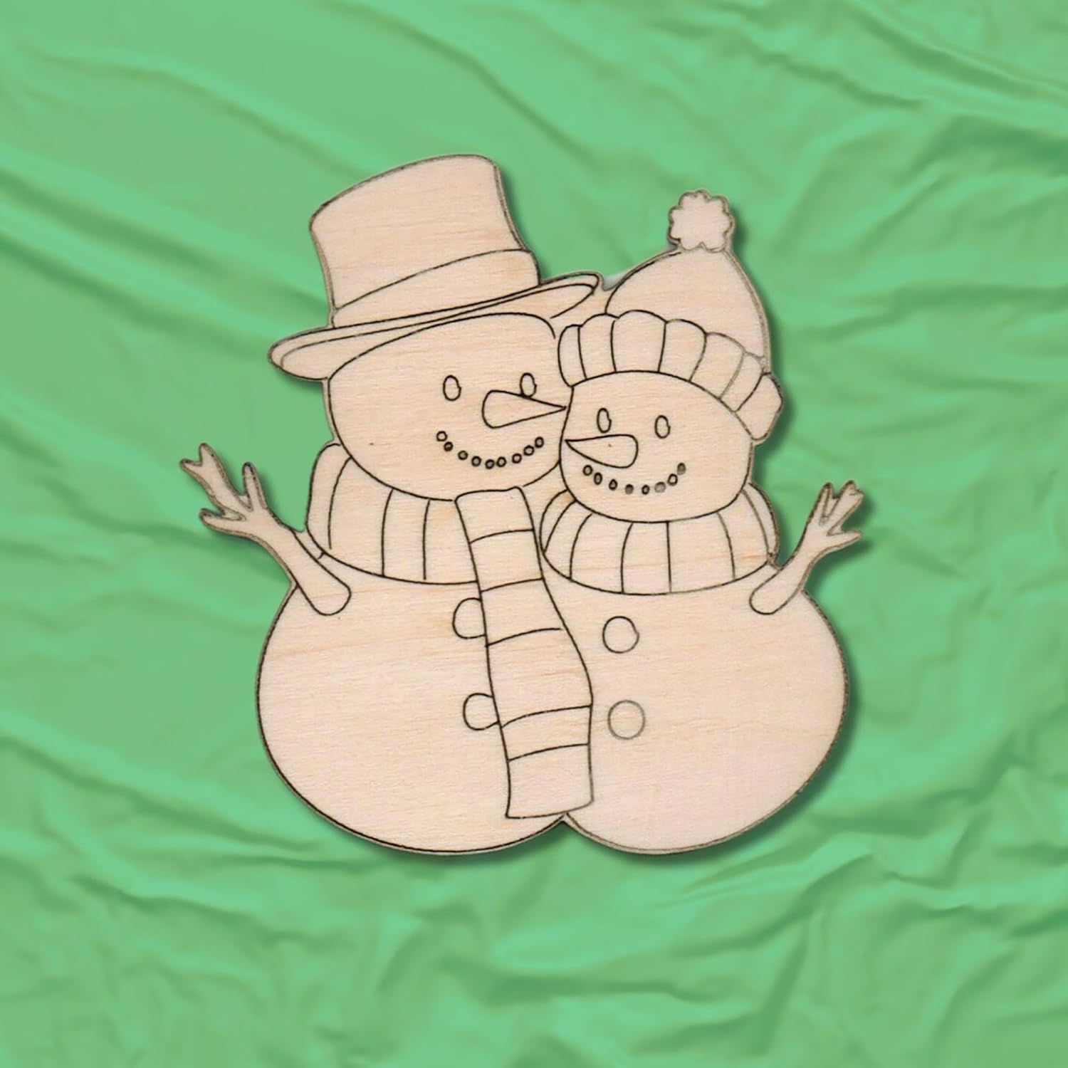 Wooden snowman cutout with top hat and scarf on a green fabric background