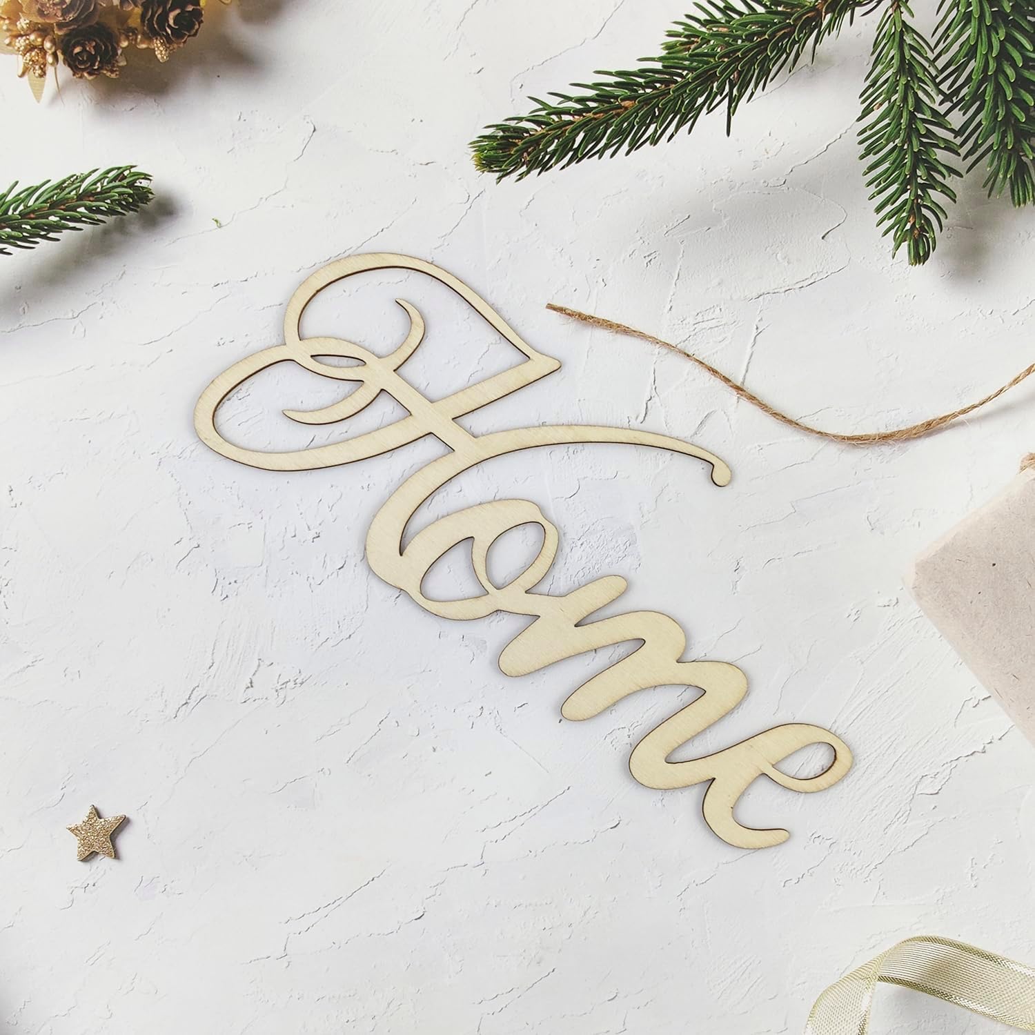 Wooden 'Home' decoration on a textured white surface with Christmas elements.