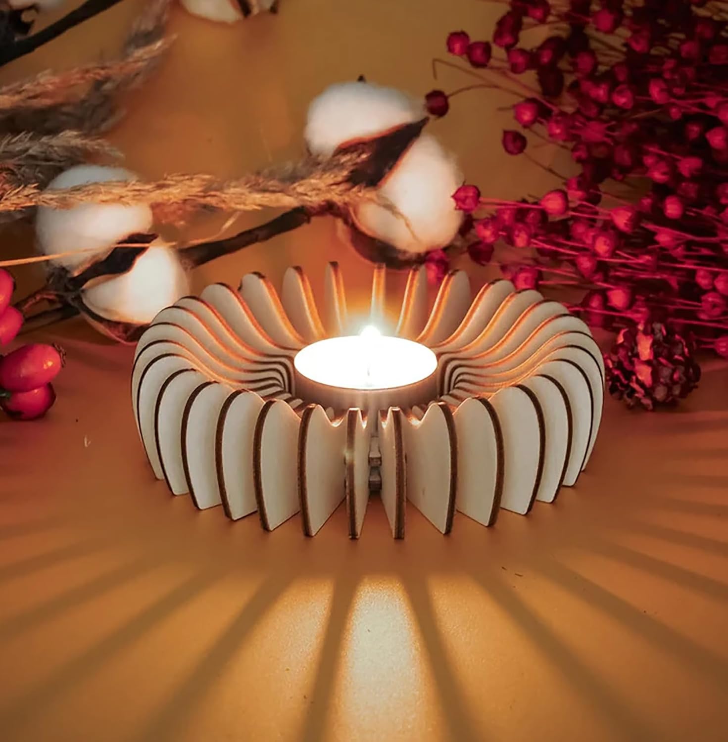 Decorative candle holder with a lit candle on a wooden surface with decorative elements.