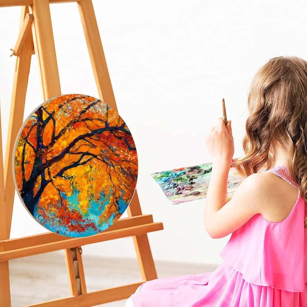 Child painting a colorful tree on an easel with a white background