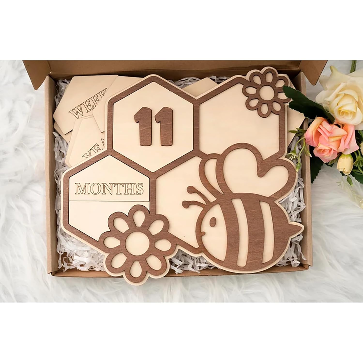 Wooden baby milestone card with bee design and '11 months' text, placed in a box.