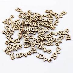 Wooden 'love' letter charms scattered on a white background