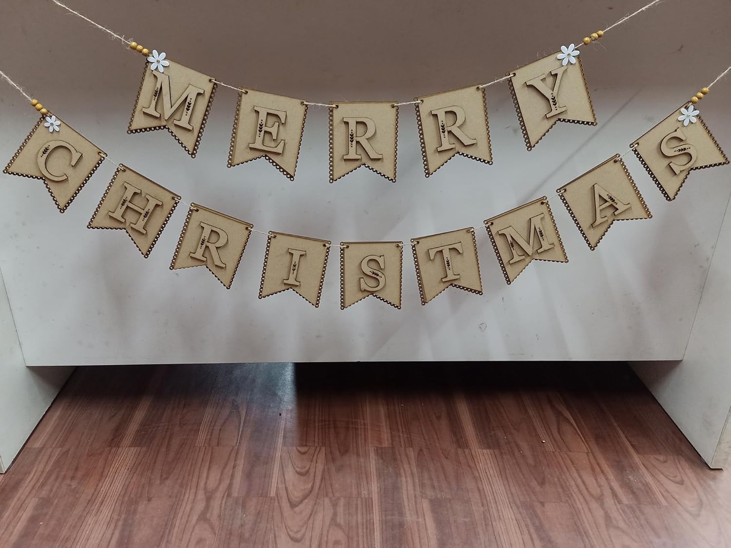 Merry Christmas banner hanging on a wall with wooden floor below