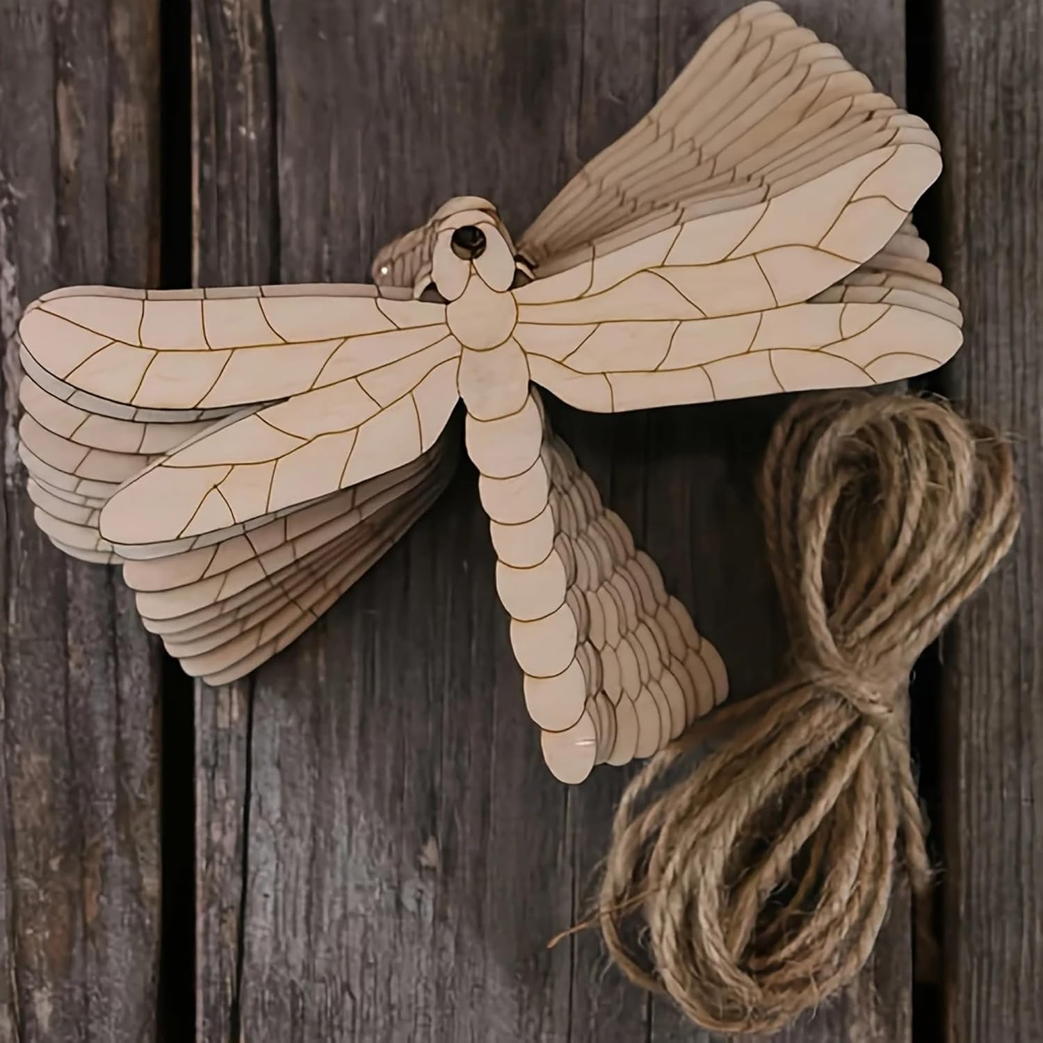Wooden dragonfly decoration with twine on a wooden background