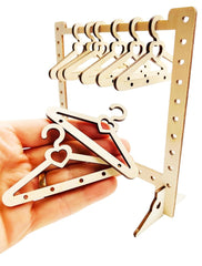 Wooden hanger organizer with multiple hooks held by a hand on a white background