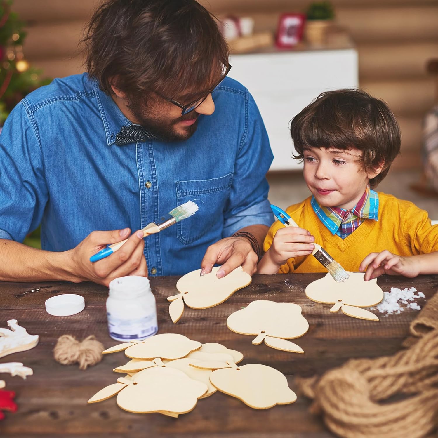 Man and child decorating cookies on a wooden table