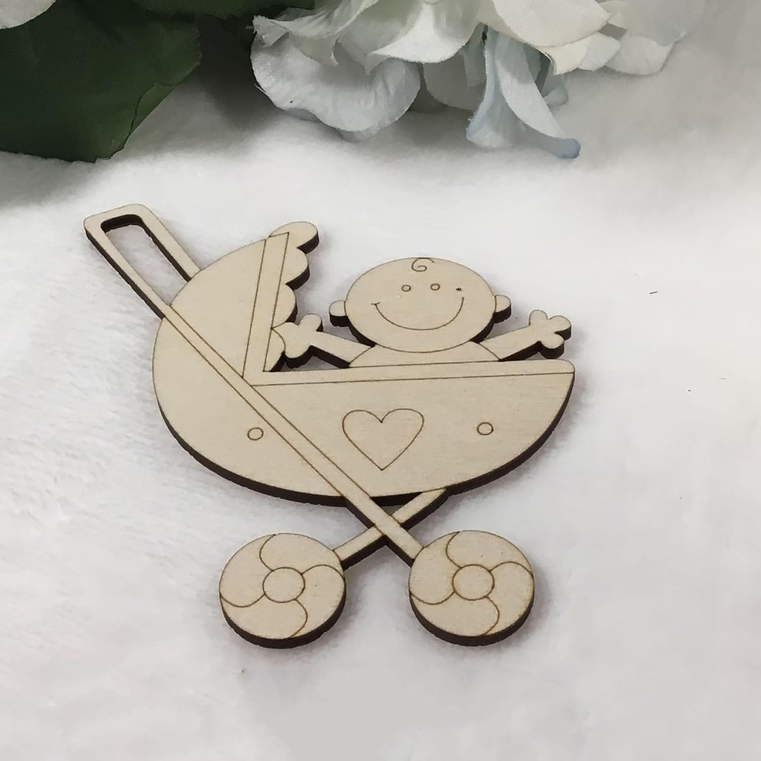 Wooden baby carriage ornament with a baby figure on a white background