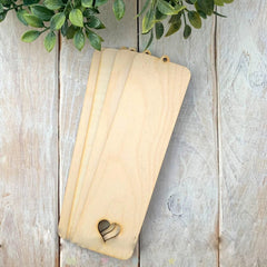 Set of wooden cutting boards with a heart design on a rustic wooden surface.