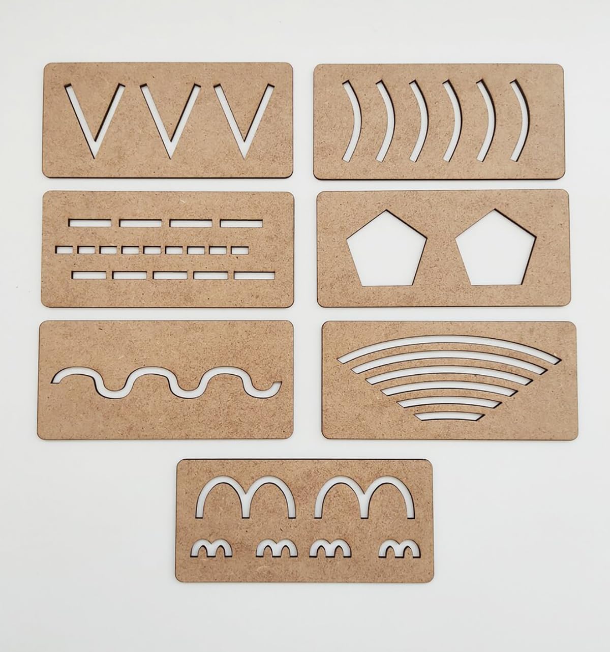 Set of cardboard stencils with various shapes and patterns on a white background