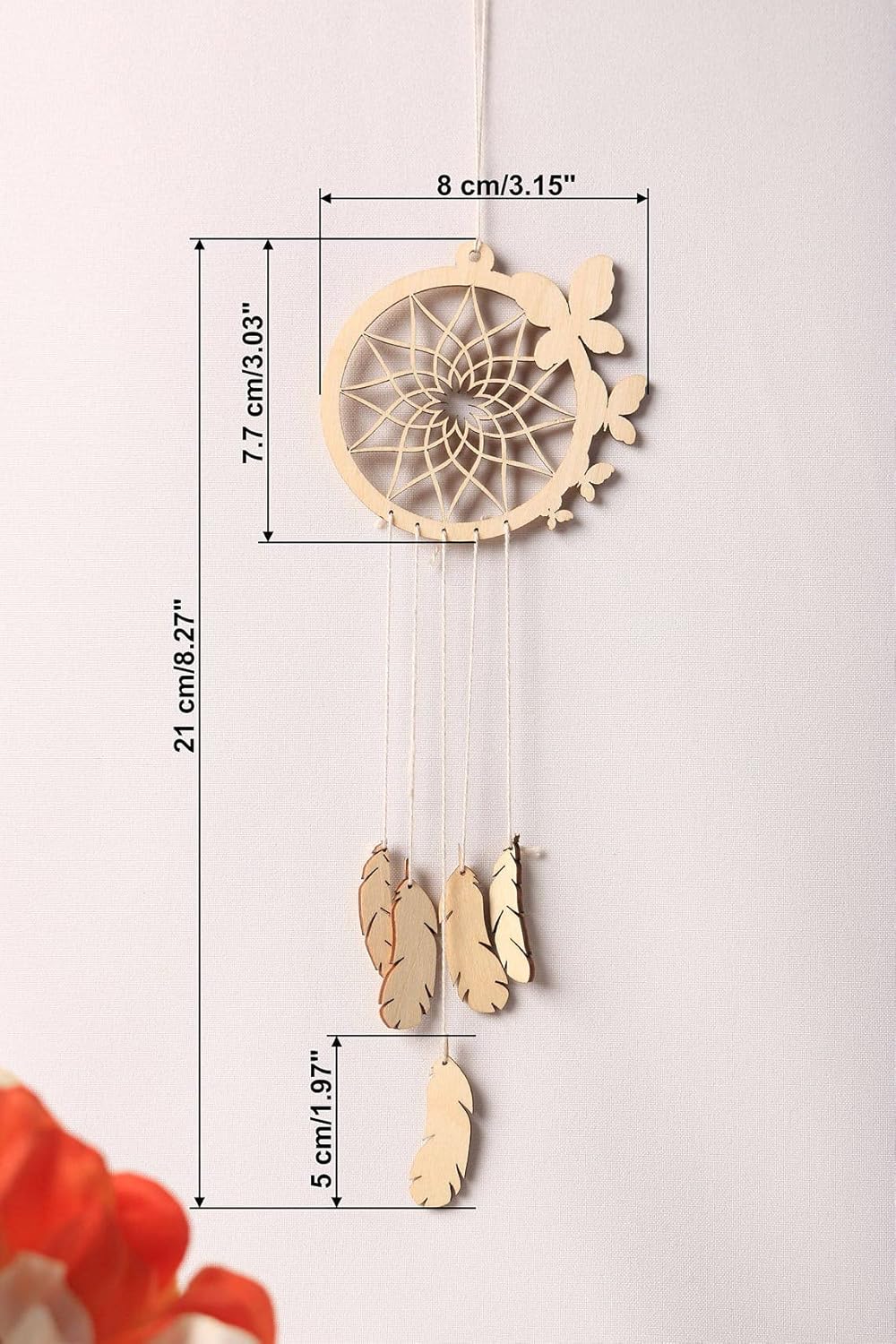Wooden dreamcatcher with feathers and measurements on a light background
