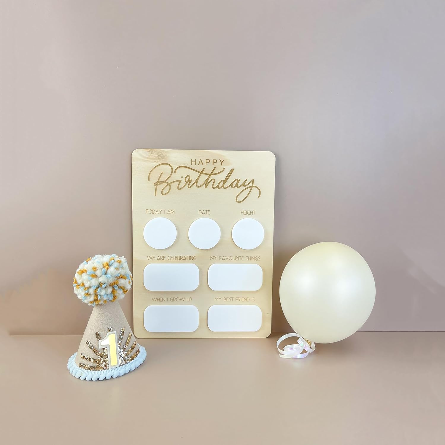 Wooden birthday card with white circles, a small cake model, and a balloon on a beige background