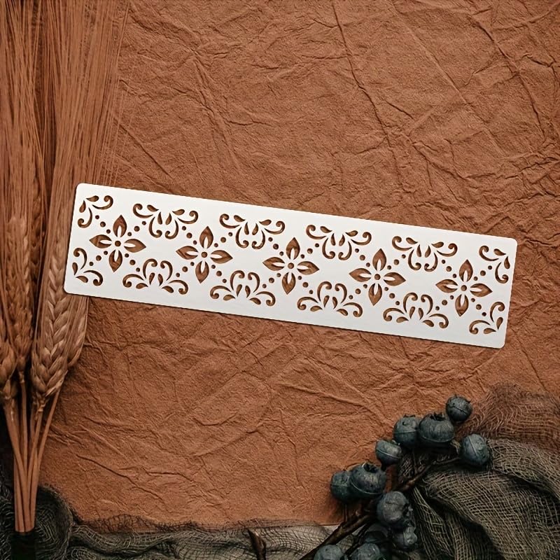 Decorative metal stencil with floral patterns on a textured brown surface.