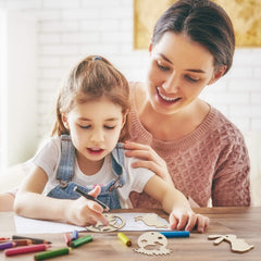 Woman and child engaged in a craft activity with wooden shapes and markers.