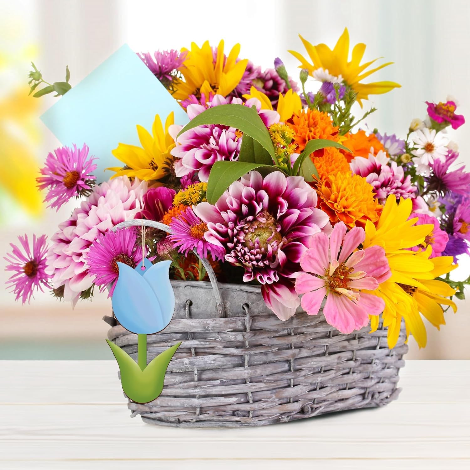 Colorful bouquet of flowers in a woven basket with a tulip-shaped sign.