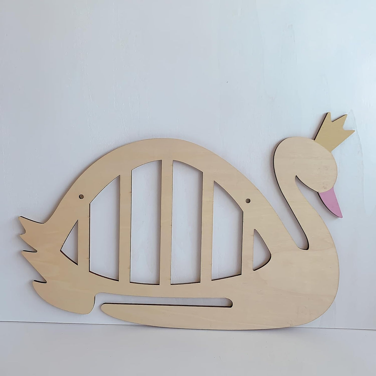 Wooden swan cutout with a pink beak on a white background