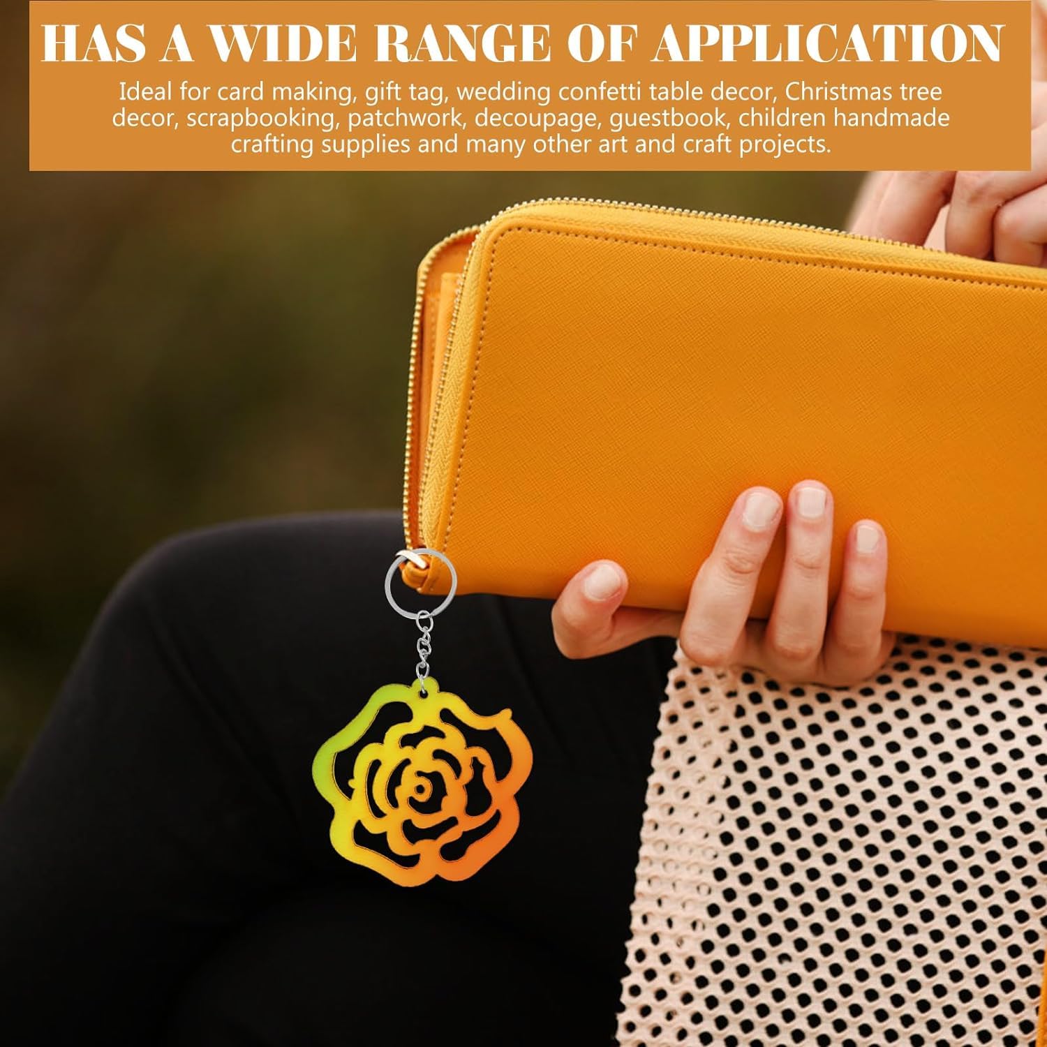 Yellow wallet with a colorful rose-shaped keychain held by a person.