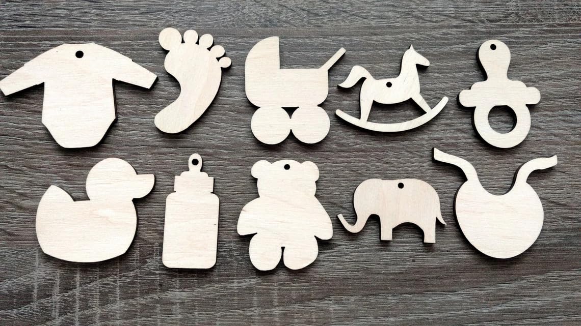 Set of wooden baby-themed ornaments on a wooden surface