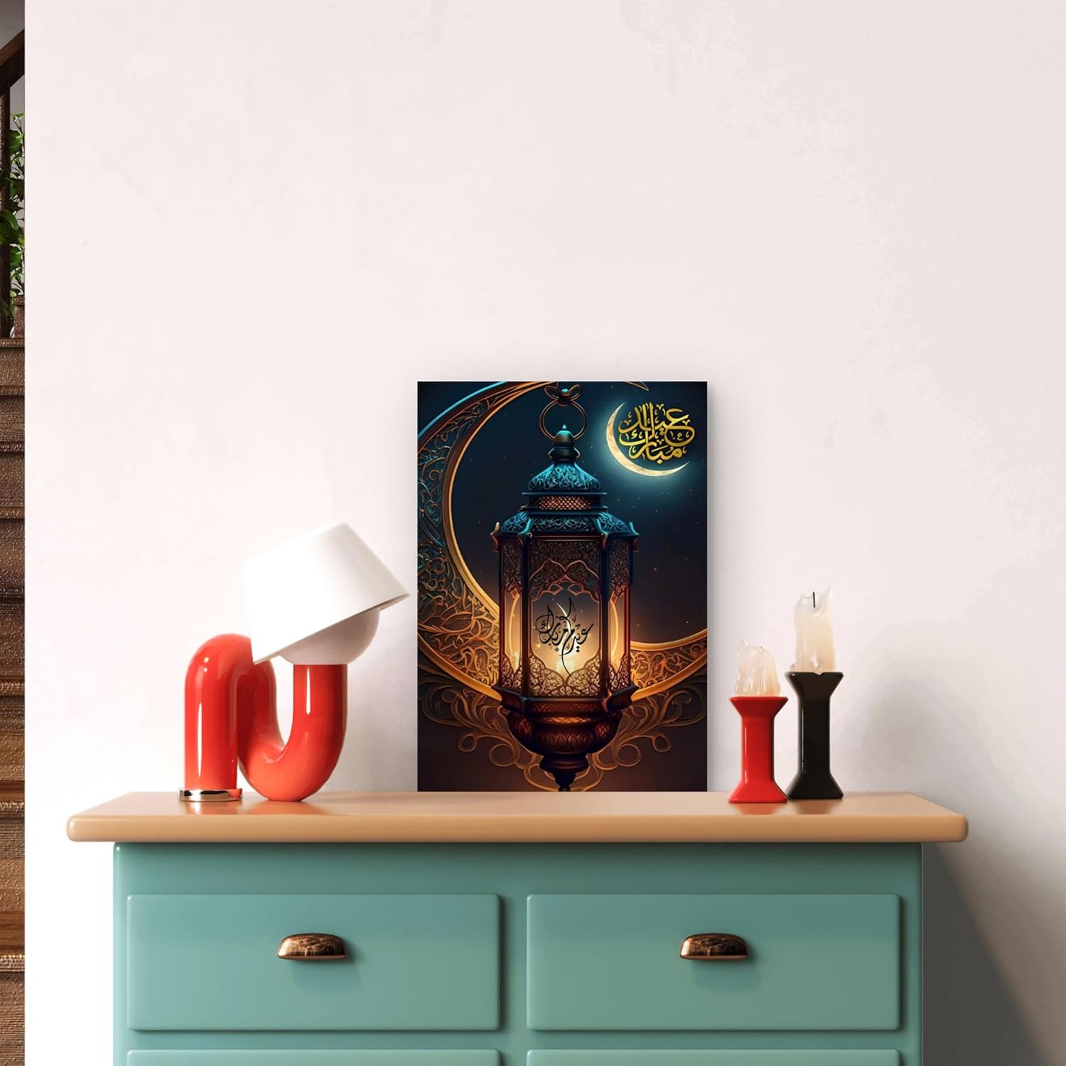 Decorative wall art with a lantern design on a white wall above a teal cabinet.