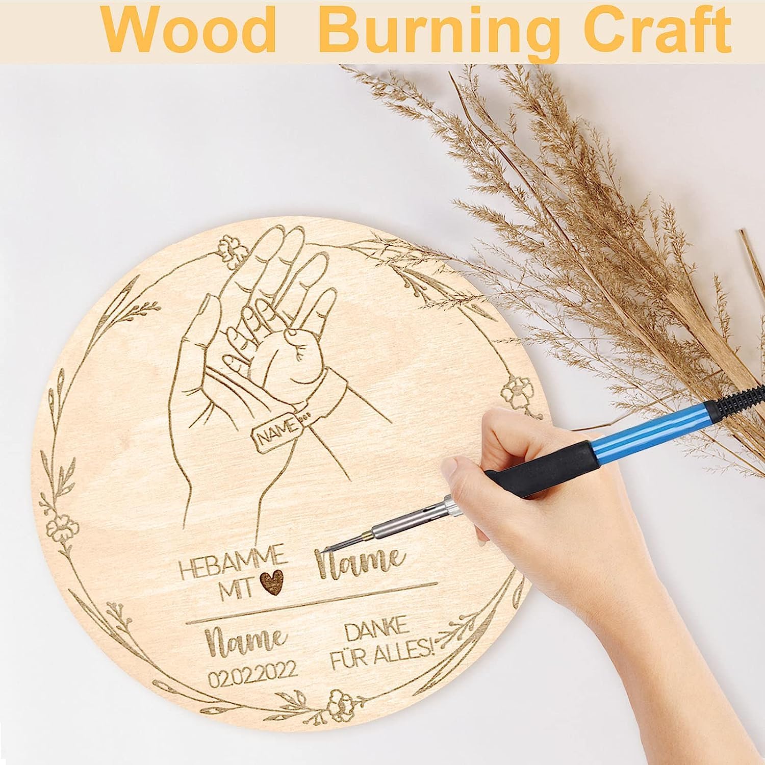 Wood burning craft with hands and text on a wooden board, surrounded by dried plants.