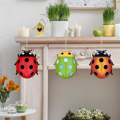 Colorful ladybug decorations hanging on a fireplace mantle with candles and plants.