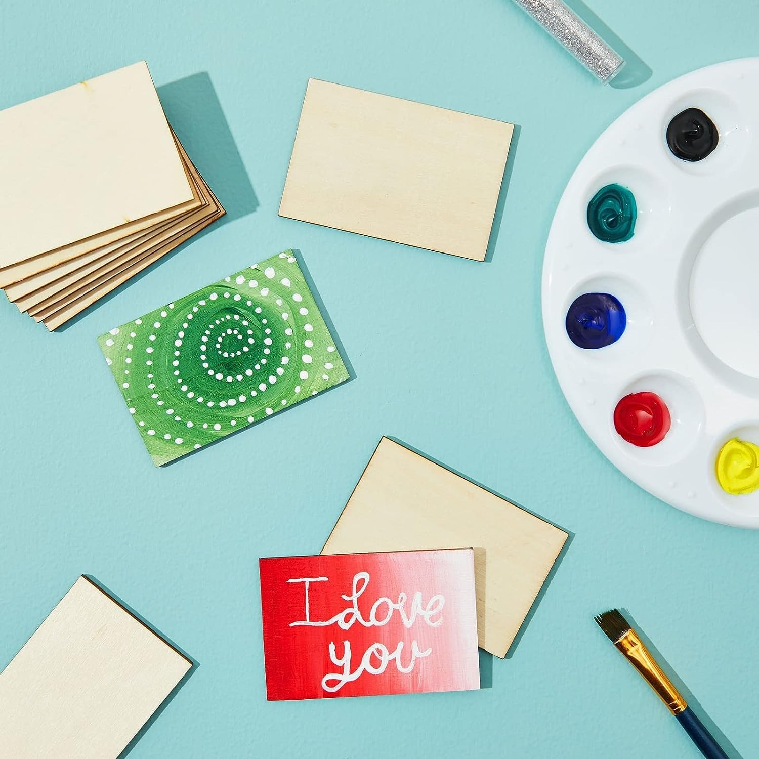 Colorful greeting cards with paint palette and brushes on a light blue background