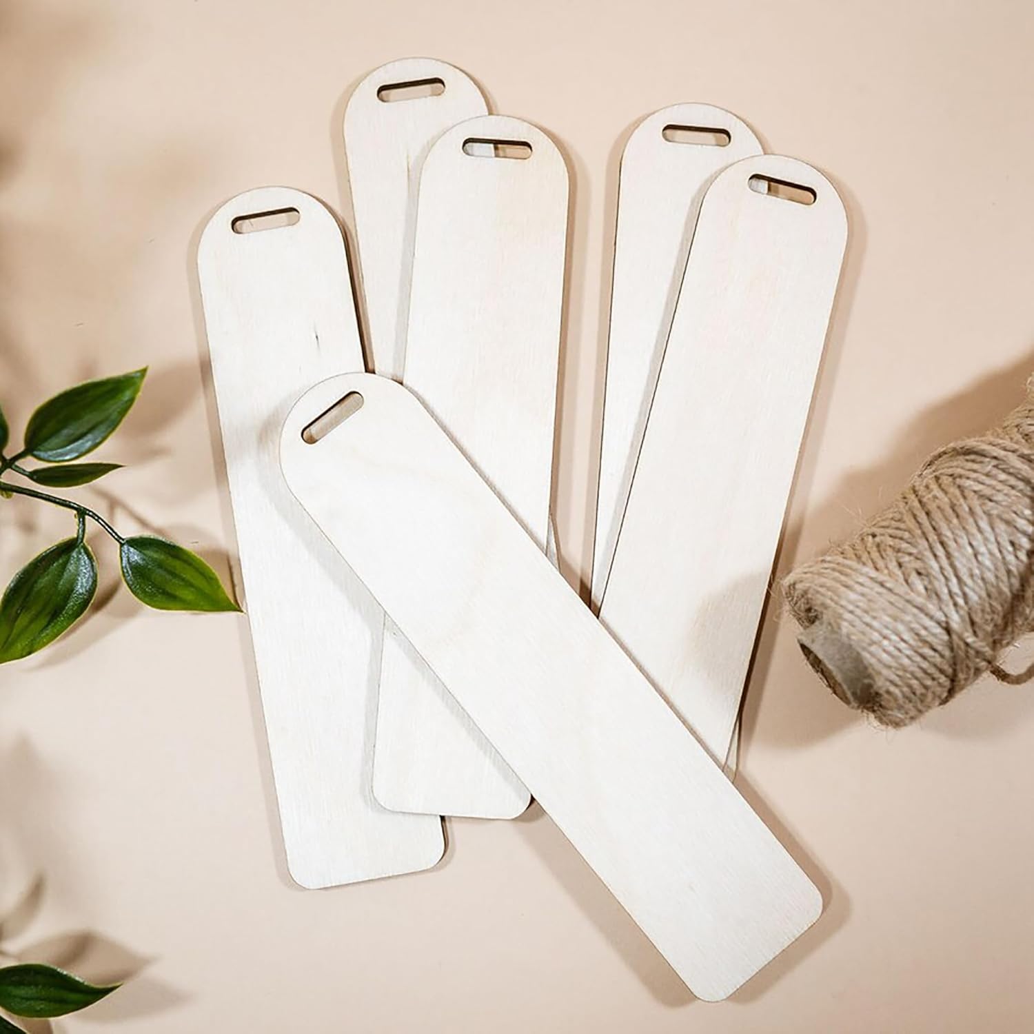 Set of white wooden slats on a beige surface with a plant and twine.