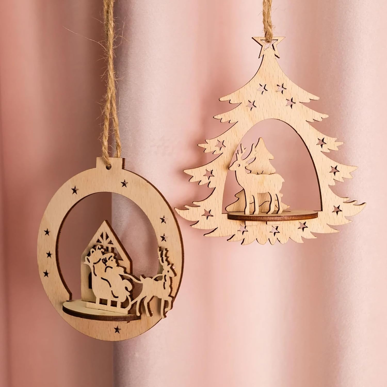Two wooden Christmas tree ornaments on a pink background