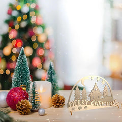 Decorative Christmas scene with small trees, a candle, and a 'Merry Christmas' sign.