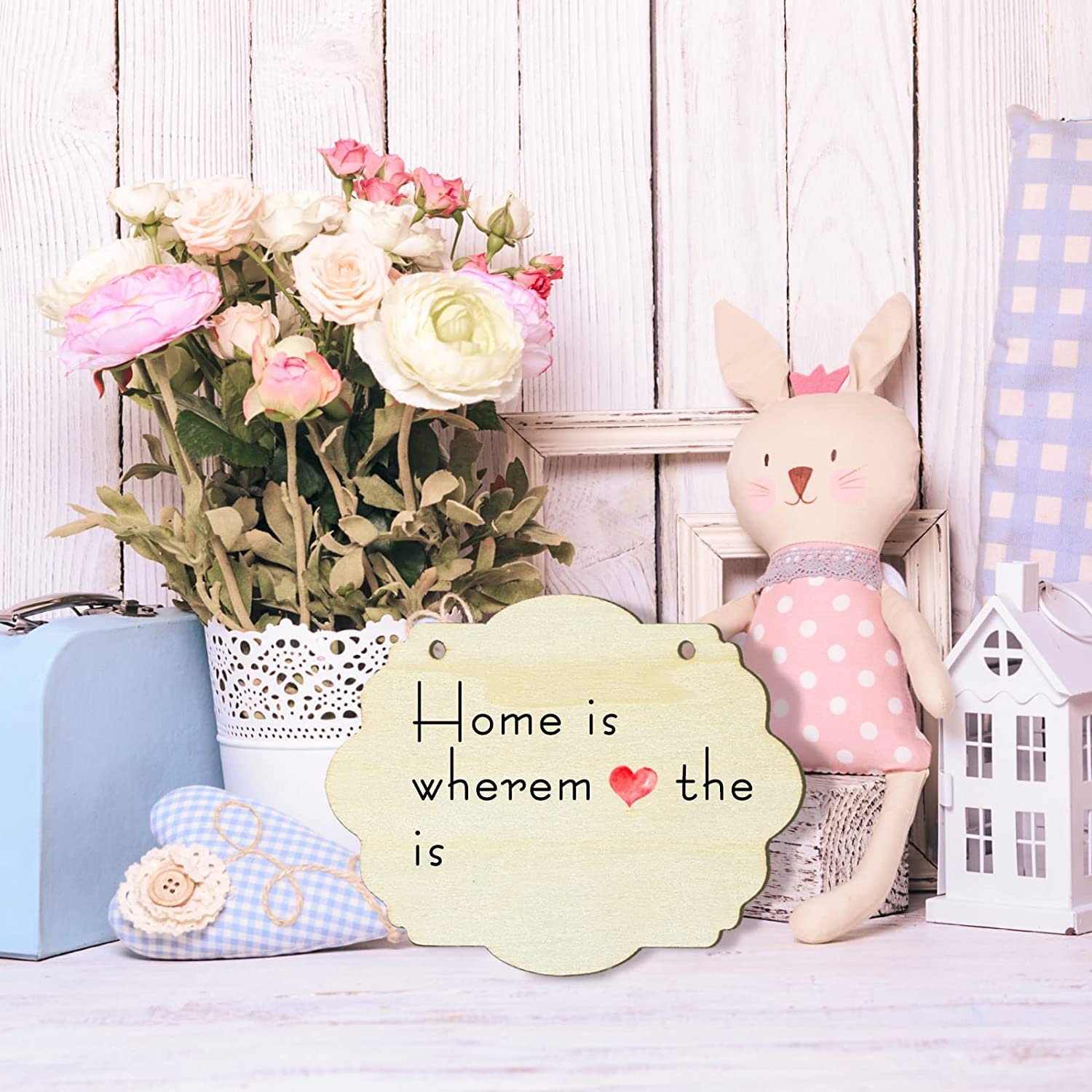 Decorative scene with a rabbit plush toy, flowers, and a sign on a wooden background